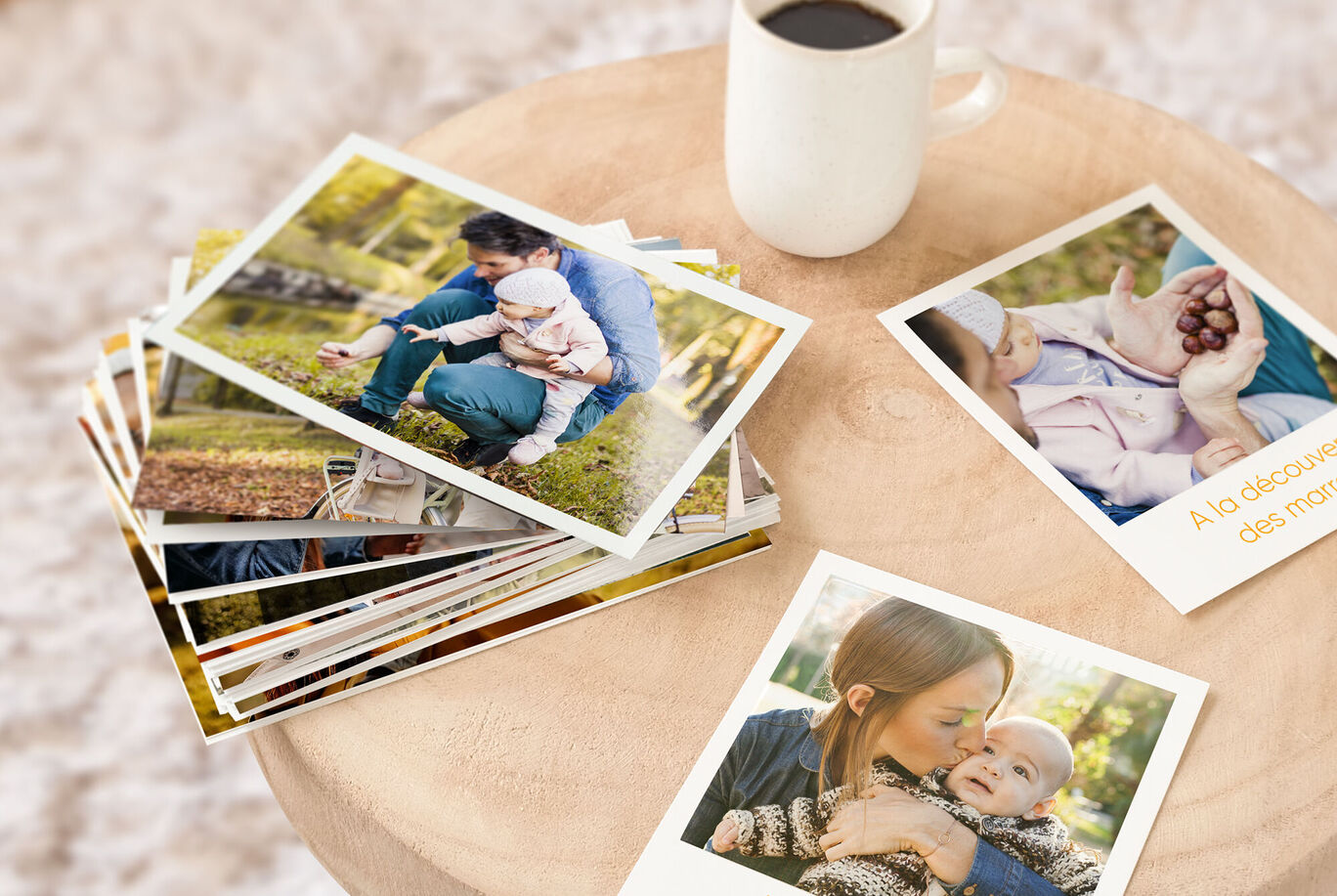 Photos empilées sur une table en bois avec une tasse de café.