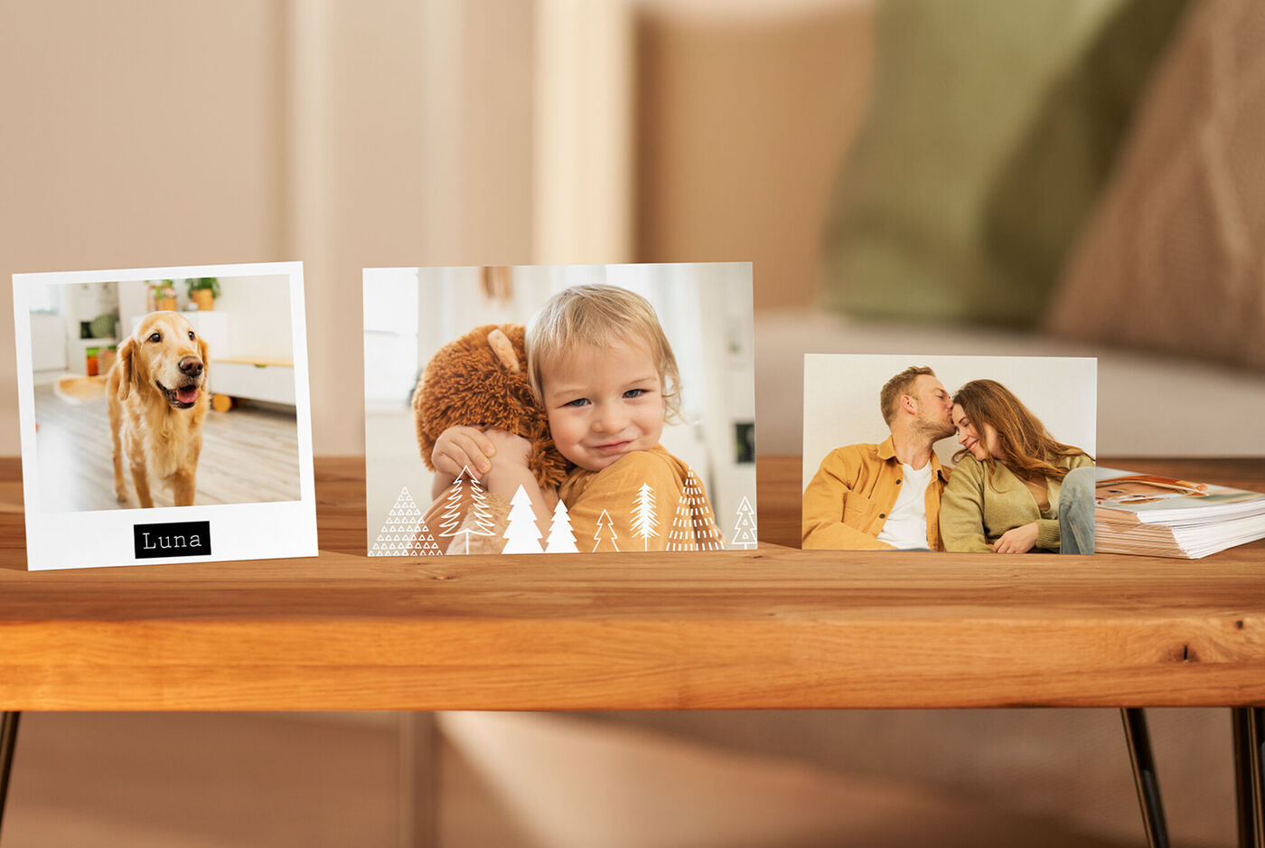 Drie foto’s op een houten tafel. Links een foto van een hond met de naam 'Luna', midden een kind met teddybeer, rechts een lachend koppel.