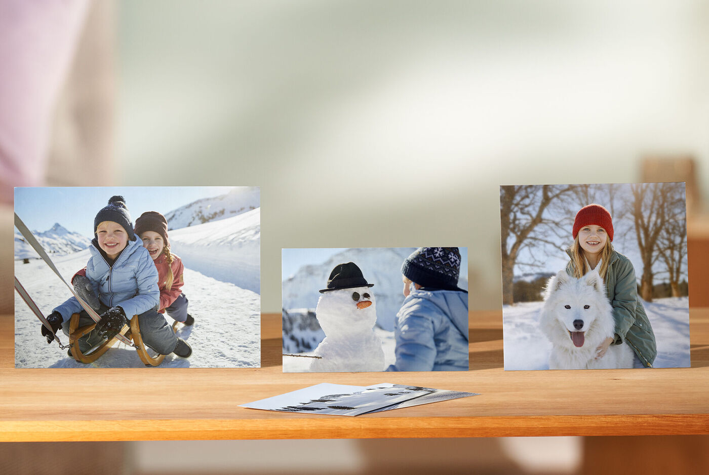 Drie vrolijke foto's van kinderen in de sneeuw, twee met een sneeuwpop en een andere met een hond.